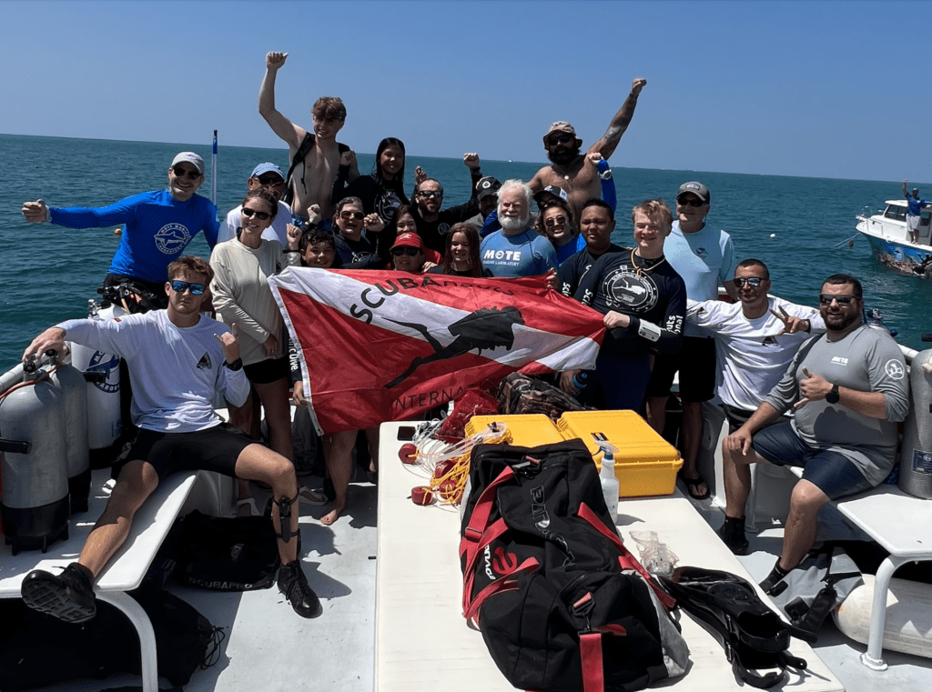 Mote, CWVC, and SNI divers on boat during coral restoration initiative.